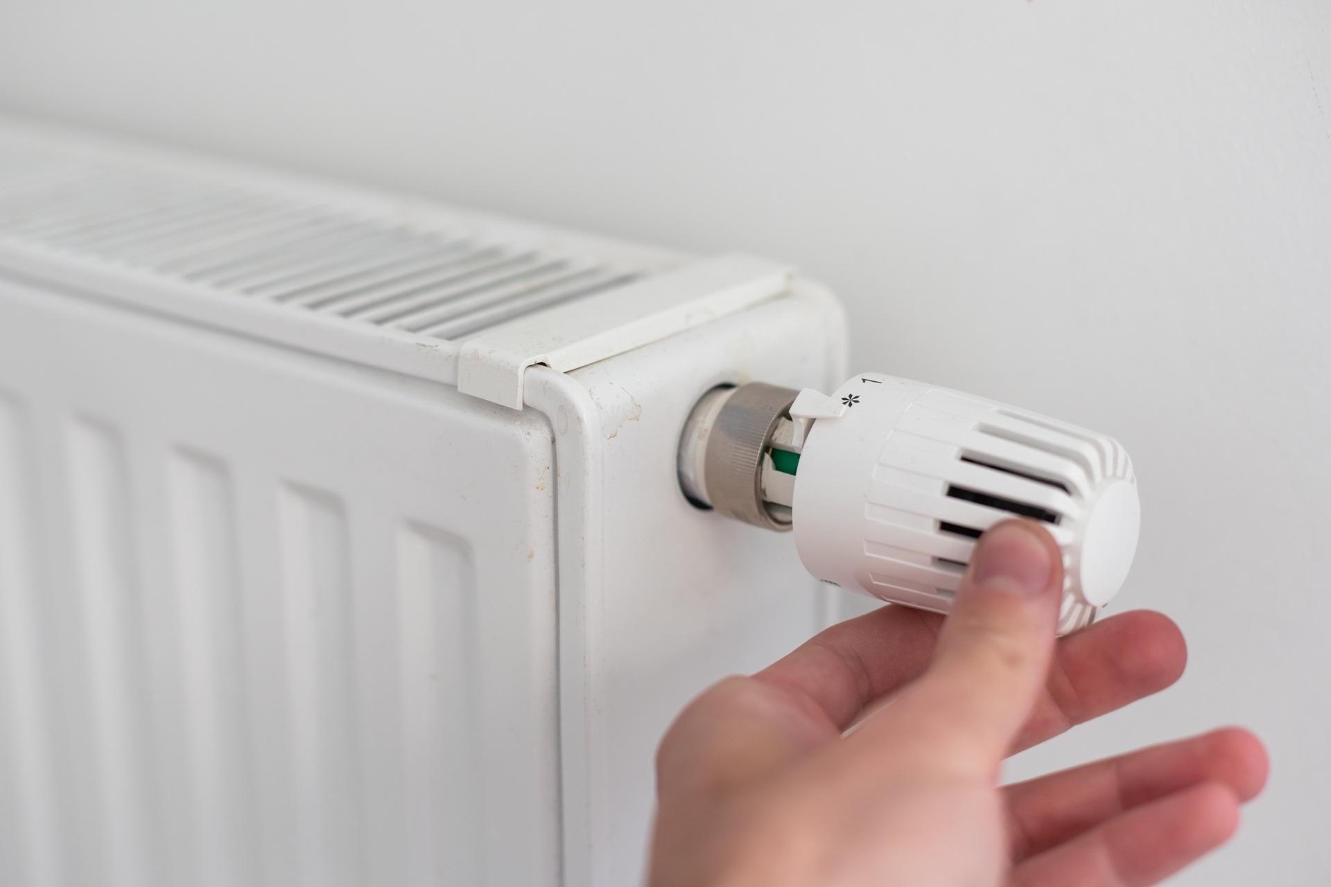 Hand dreht Thermostat zur Energieeinsparung | Regenwassernutzungsanlage

